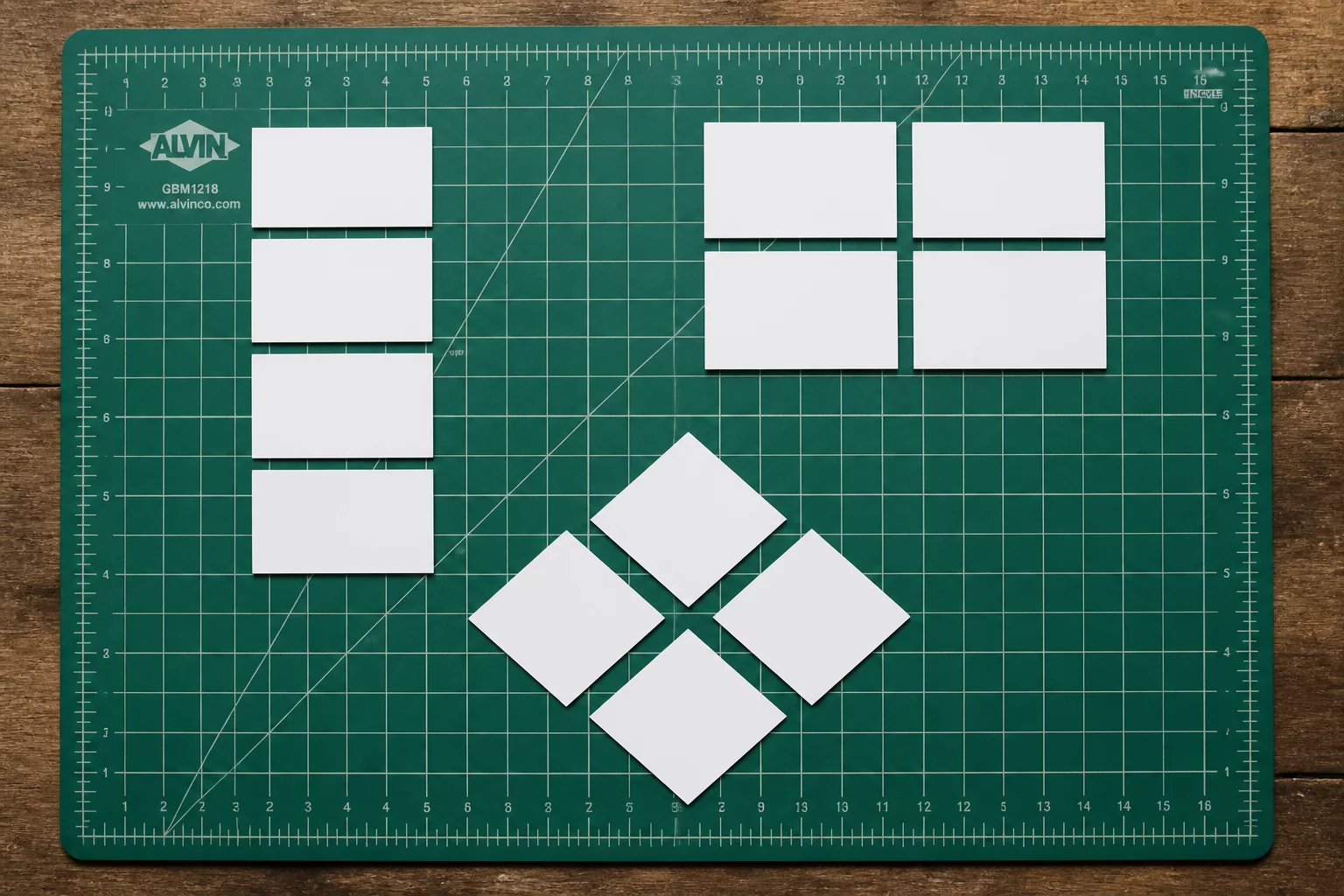 Top-down view of cutting mat with ten paper labels arranged in three distinct layout patterns